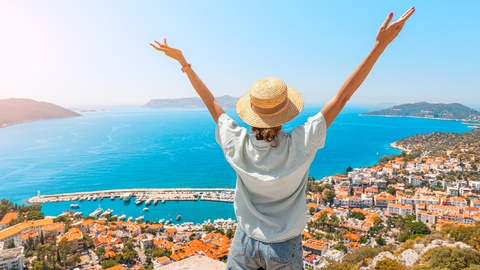 Eine Frau blickt von einem Hügel auf eine Stadt hinab. © Shutterstock