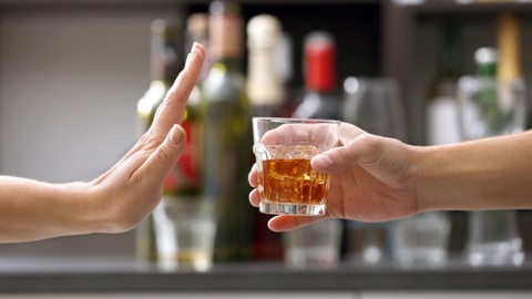 Symbolbild: Eine Frau, die ein alkoholisches Getränk ablehnt. © Shutterstock