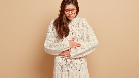 Eine Frau mit Bauchschmerzen. © Shutterstock