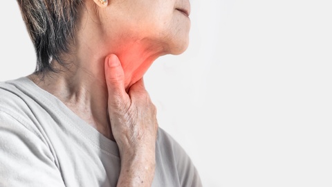 Symbolbild: Eine ältere Frau greift sich an den schmerzenden Hals. © Shutterstock
