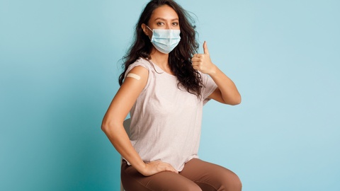 Eine Frau, die soeben geimpft wurde, hält den Daumen hoch. © Shutterstock