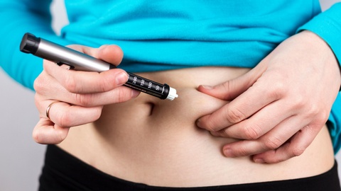 Symbolbild: Eine Frau verabreicht sich eine Insulinspritze in den Bauch. © Shutterstock