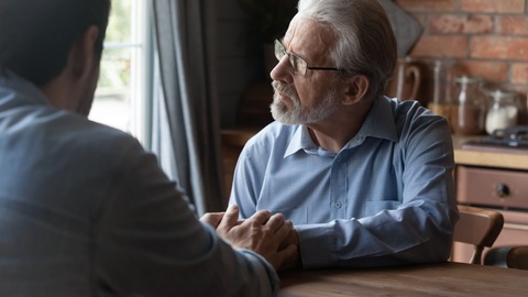 Symbolbild: Ein Mann, der besorgt aus dem Fenster sieht. © Shutterstock