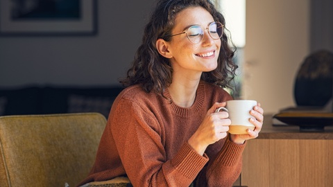 Symbolbild: Lächelnde Frau mit Kaffeetasse. © Shutterstock