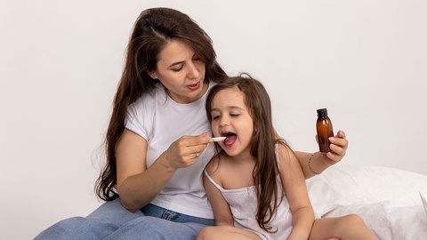 Mutter gibt Tochter Medikamente © Shutterstock
