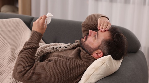 Mann liegt krank auf dem Sofa © Shutterstock