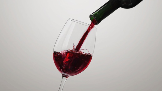In ein Glas wird Wein eingeschenkt. © Shutterstock