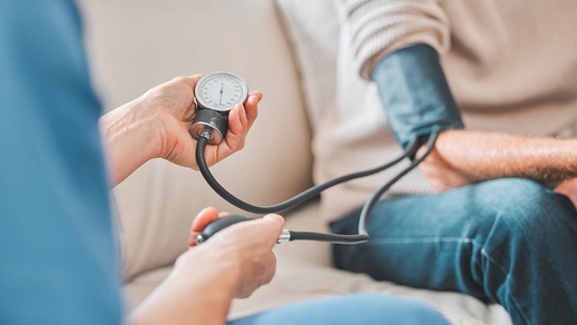 Frau misst bei einem Mann den Blutdruck © Shutterstock