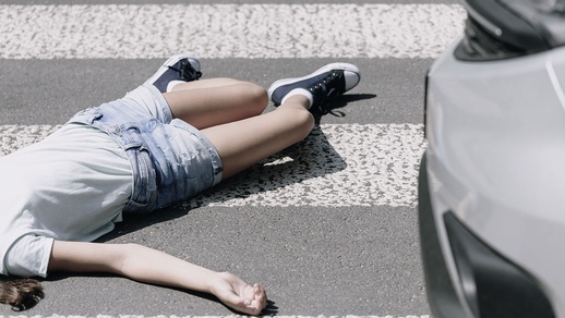 Kind liegt nach Unfall mit Auto am Boden. © iStock