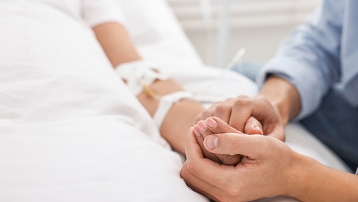 Mann hält Hand von in Koma liegender Frau © Shutterstock