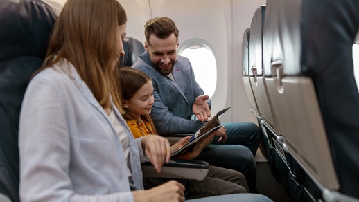 Eine Familie sitzt im Flugzeug. © Shutterstock