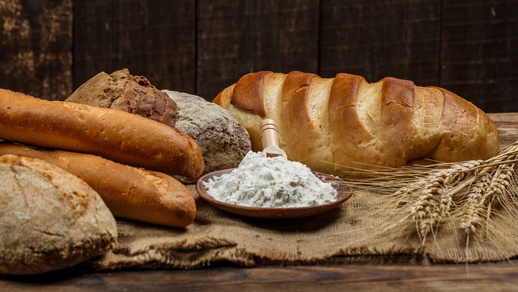 Frische Brotlaibe mit Weizen und Gluten auf einem Holztisch © Shutterstock