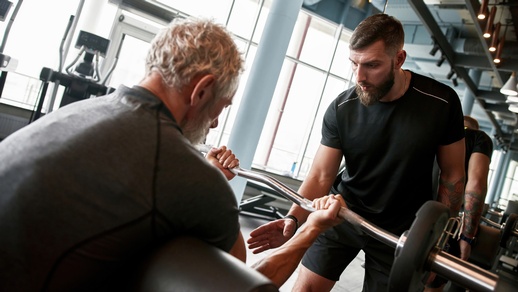 Ein Mann hebt im Fitnessraum Gewichte. © Shutterstock