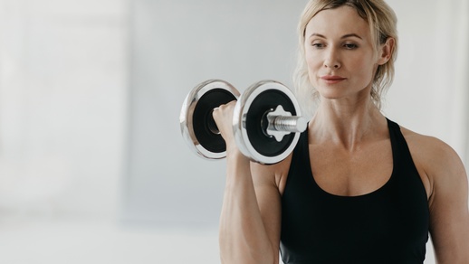 Eine Frau beim Krafttraining mit einer Hantel. © Shutterstock