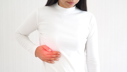 Eine Frau hält sich die Hand auf die Galle. © Shutterstock