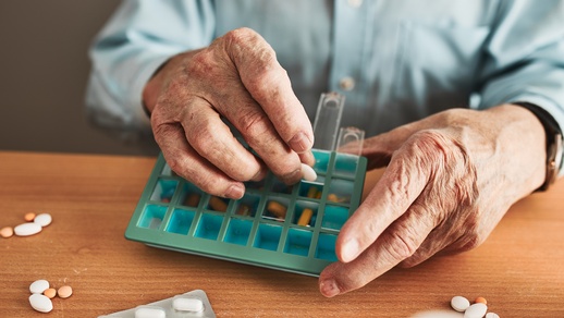 Ein älterer Herr ordnet seine Medikamente. © Shutterstock