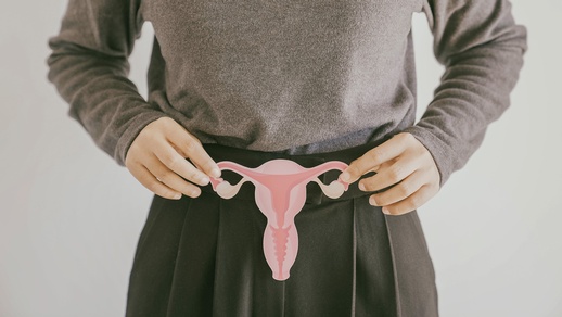 Frau hält die Darstellung einer Gebärmutter und der Eierstöcke. © Shutterstock