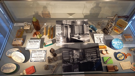 Blick in eine Ausstellungsvitrine: im Hintergrund rechts ein Inhalations-Apparat für Asthmatiker:innen um 1885; daneben ein modernes Dosieraerosol © Franz Biba