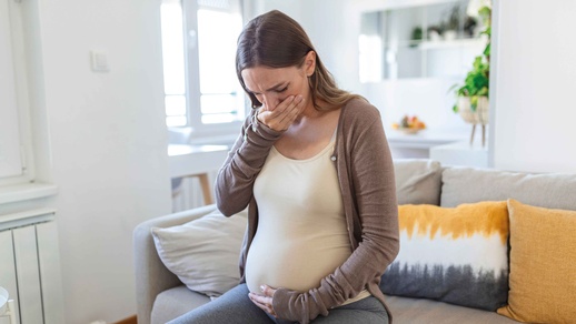 Schwangere hält sich wegen Übelkeit eine Hand vor den Mund © Shutterstock