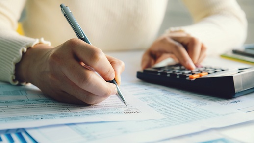 Frau mit Taschenrechner und Formular © Shutterstock