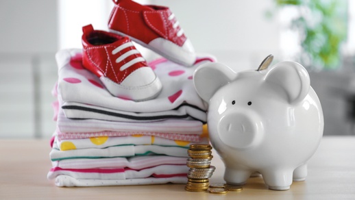 Im Bild: Ein Sparschwein und Kinderschuhe. © Shutterstock
