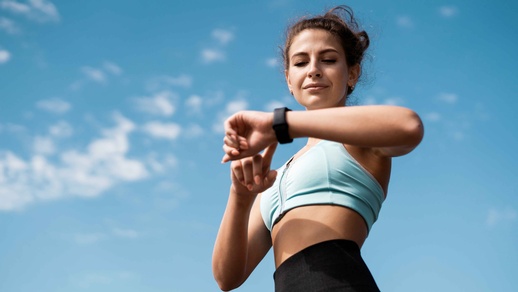 Frau trainiert und sieht auf die Uhr © Shutterstock