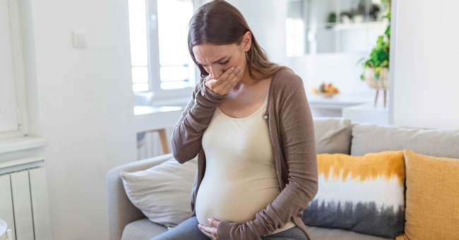 Schwangere hält sich wegen Übelkeit eine Hand vor den Mund © Shutterstock