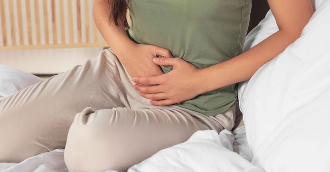 Frau hält sich schmerzenden Bauch © Shutterstock
