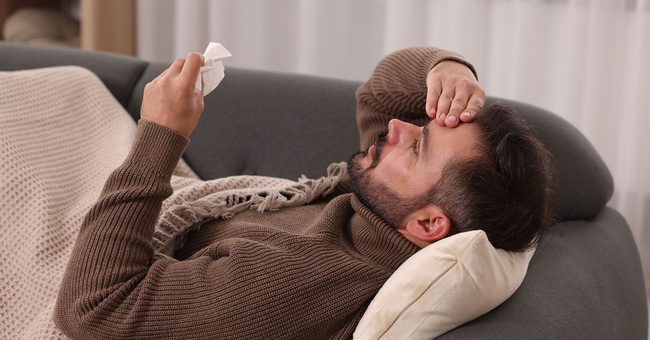 Mann liegt krank auf dem Sofa © Shutterstock