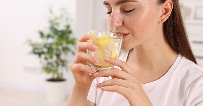 Frau trinkt Zitronenwasser © Shutterstock