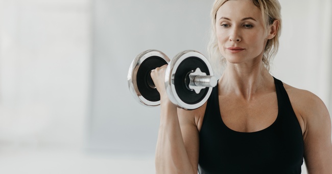 Eine Frau beim Krafttraining mit einer Hantel. &copy; Shutterstock