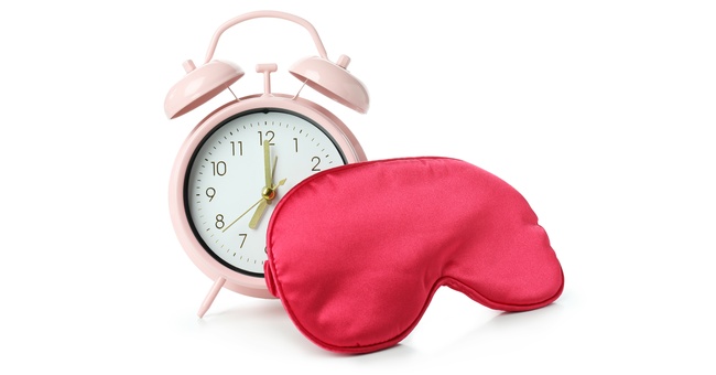 Ein Wecker und eine Schlafmaske symbolisieren das Thema Schlaf. © Shutterstock