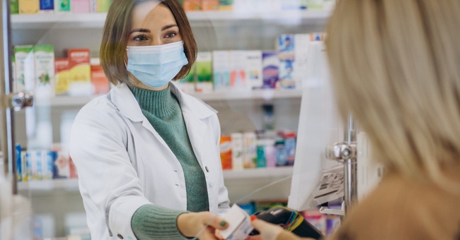 Eine Apothekerin trägt bei der Arbeit einen Mund-Nasen-Schutz. © Shutterstock