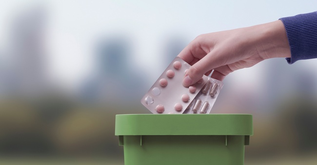 Symbolbild: Eine Frau entsorgt alte Medikamente in einer Mülltonne. © Shutterstock