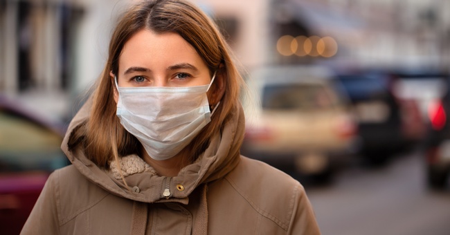 Eine Frau mit einem Mund-Nasen-Schutz. © Shutterstock
