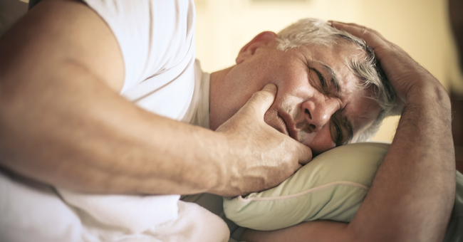 Liegender Mann hat Schmerzen im Kiefer.  © iStock