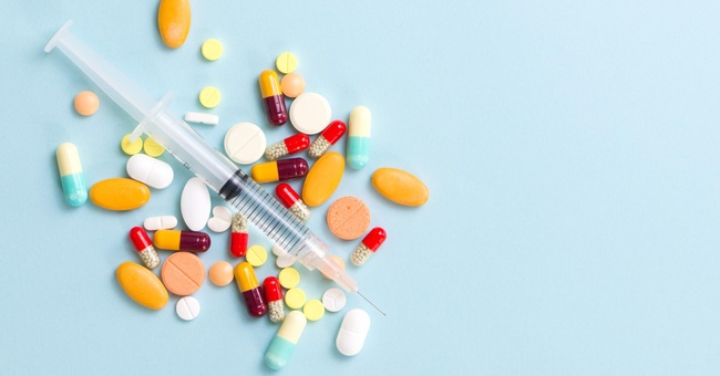 Spritze und Medikamente auf blauem Hintergrund © Shutterstock