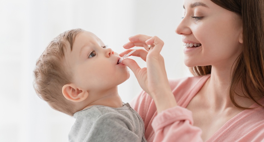 Eine Mutter verabreicht ihrem Kind ein Medikament © Shutterstock