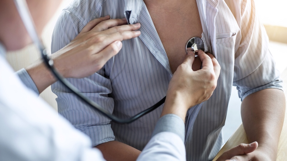 Arzt, der einen Patienten mit einem Stethoskop untersucht. © Shutterstock