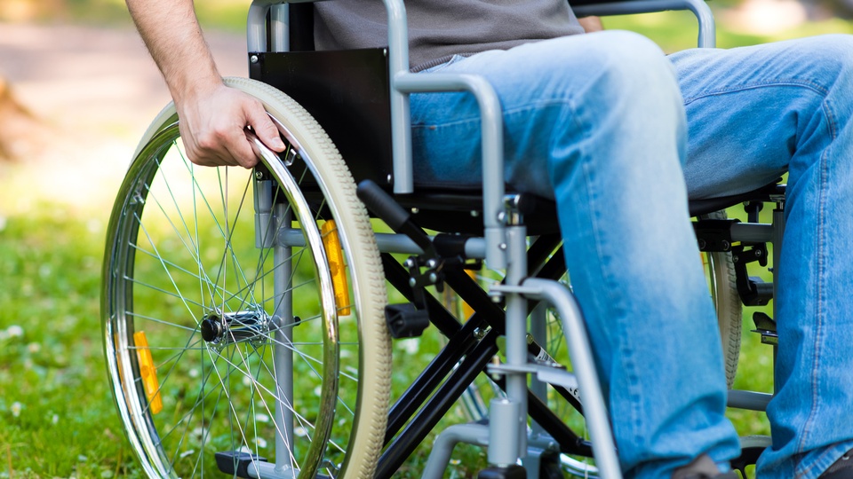 Eine Person sitzt im Rollstuhl. © Shutterstock