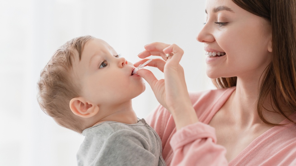 Eine Mutter verabreicht ihrem Kind ein Medikament © Shutterstock