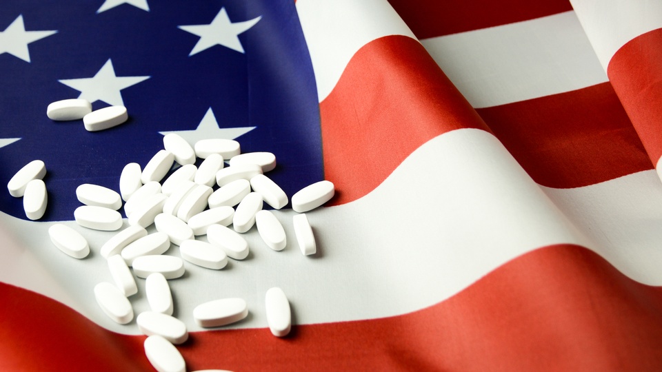 Symbolbild: Medikamente liegen auf US-Flagge. © Shutterstock