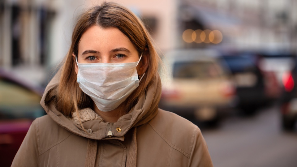 Eine Frau mit einem Mund-Nasen-Schutz. © Shutterstock