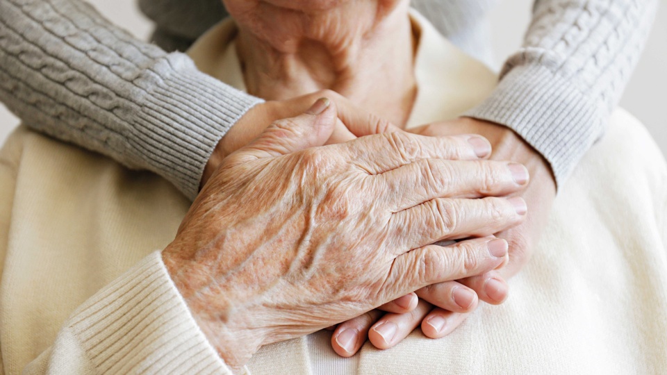 Hand einer alten Person hält jüngere Hände © Shutterstock