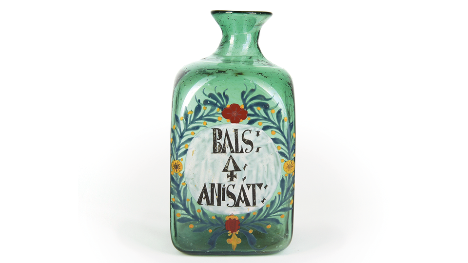 © HBF Ziergefäß aus grünem, mundgeblasenem Glas. Laut Beschriftung enthielt das Gefäß einst „Anishaltigen Schwefel- balsam“. Schwefel ist mit dem alchemistischen Zeichen angegeben. © HBF