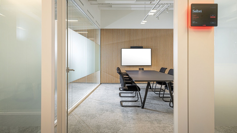 Helle R&auml;ume in Holzoptik, h&ouml;henverstellbare Schreibtische und gro&szlig;z&uuml;gige Glasfronten  mit Panoramablick: Die neuen APOVERLAG-R&auml;umlichkeiten vereinen modernes Design mit funktionaler Ausstattung. Mehrere Meetingr&auml;ume bieten Platz f&uuml;r Veranstaltungen jeder Gr&ouml;&szlig;e. &copy; APOVERLAG/Lukas Lorenz